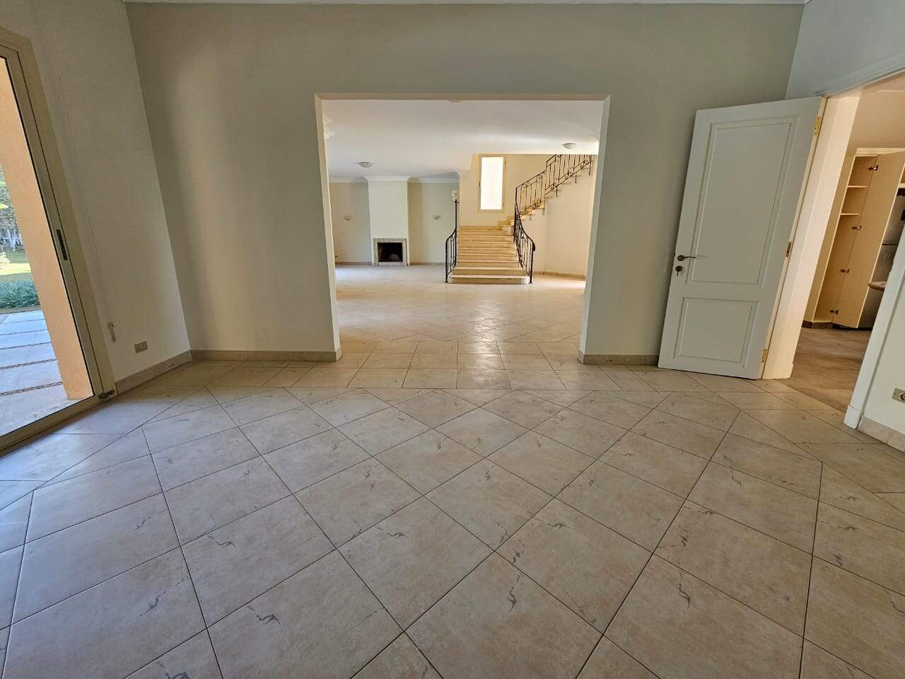 Bright living room with large glass door opening to outdoor space in Maadi Cairo apartments for rent.