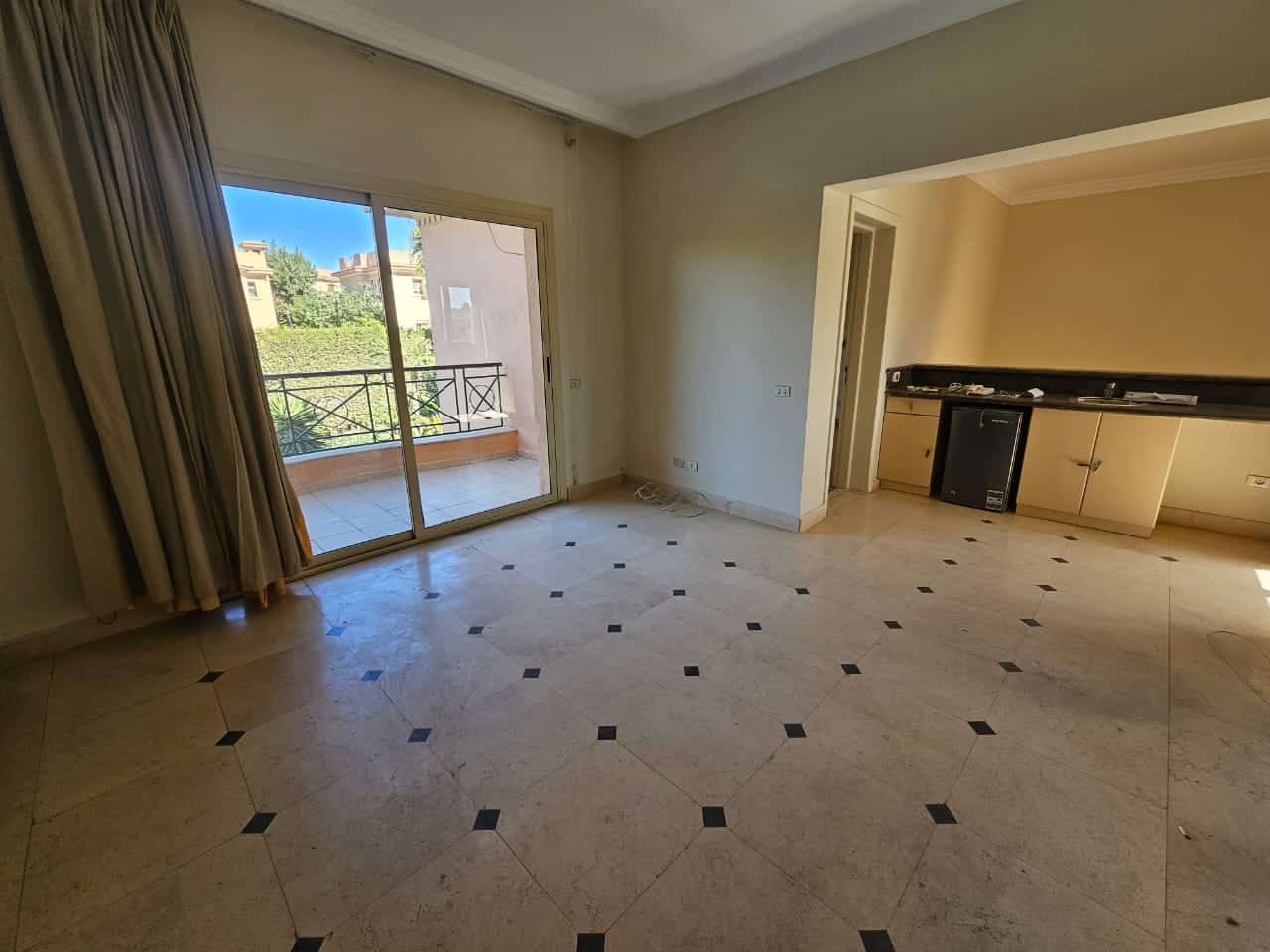 Bright living room with balcony access, overlooking lush greenery in Maadi Cairo Egypt.