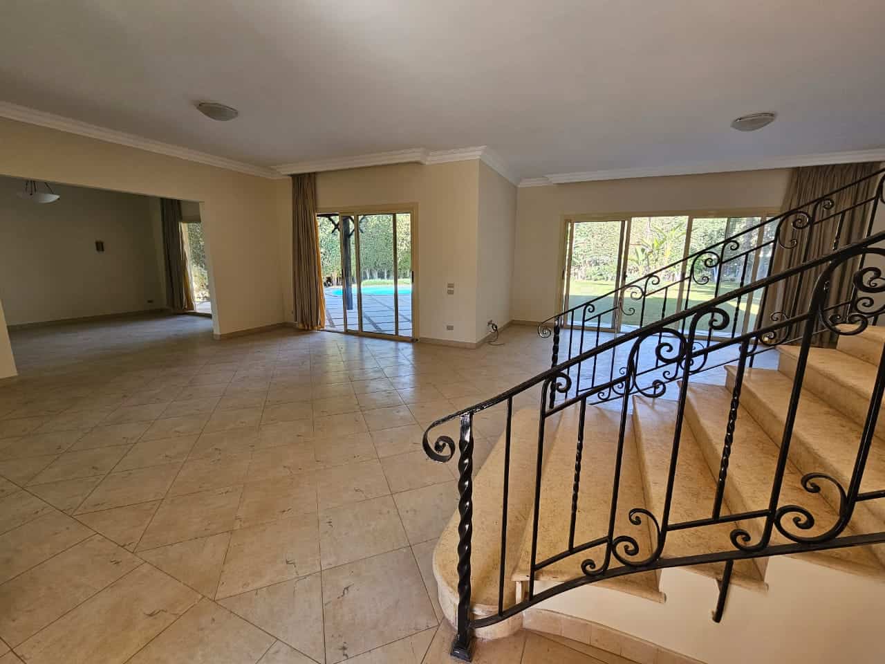 Spacious living room with large windows and outdoor access in Maadi Cairo apartment for rent.