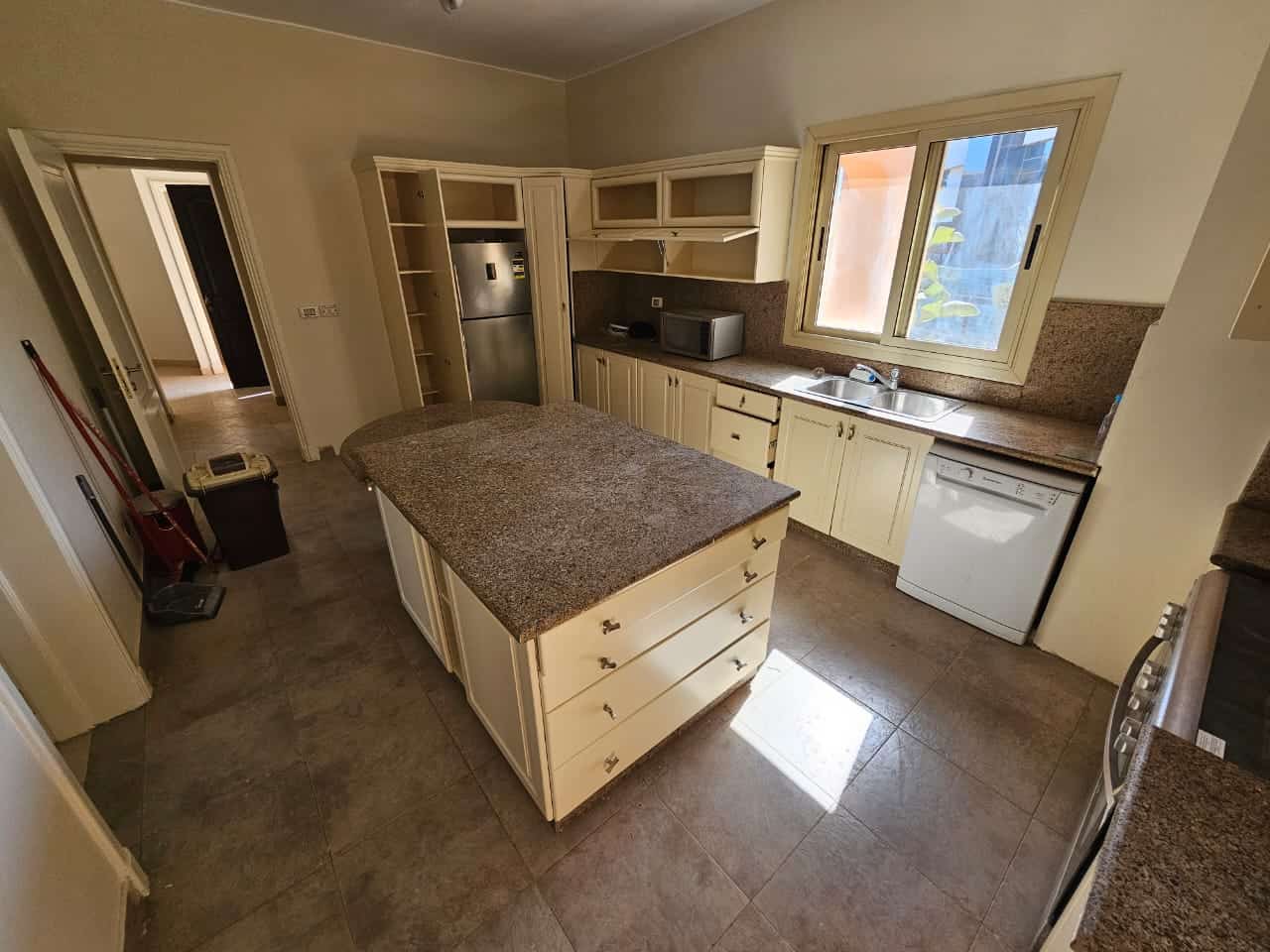 Spacious kitchen in Maadi Cairo apartment with cream cabinetry and granite countertops.