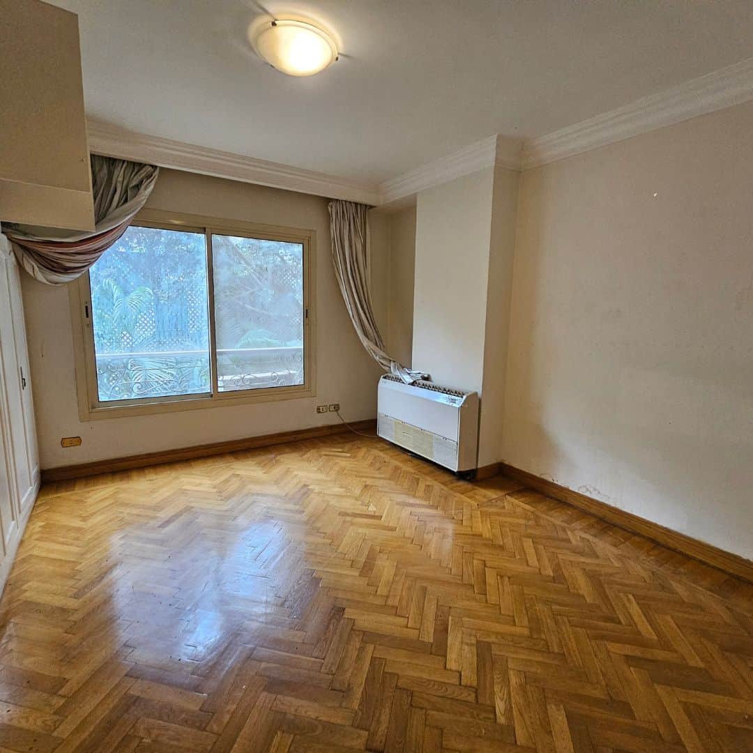 Bright unfurnished living room with large window and hardwood floors in Maadi Cairo Egypt.