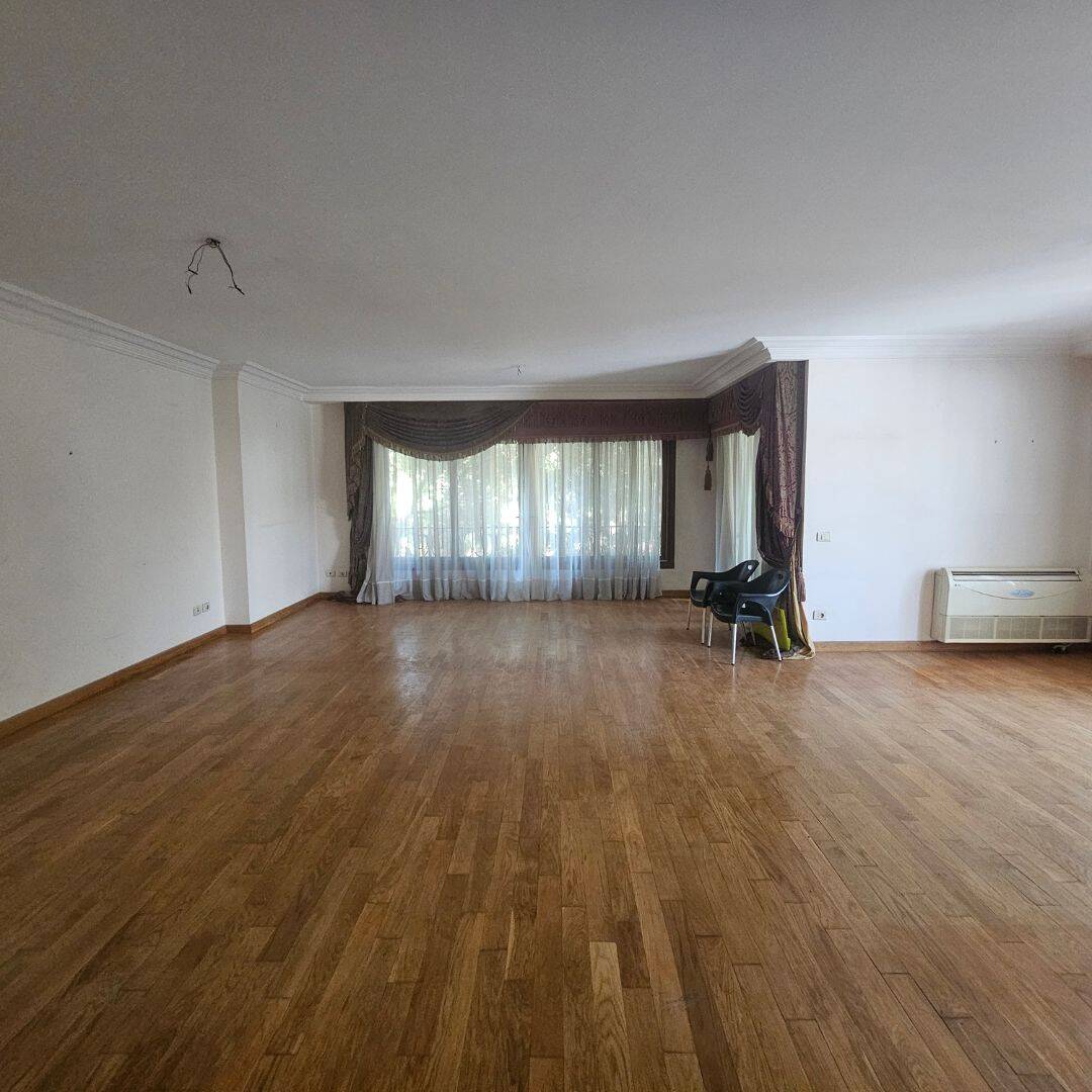 Spacious living room in a luxury Maadi Cairo apartment with large windows and wooden flooring.