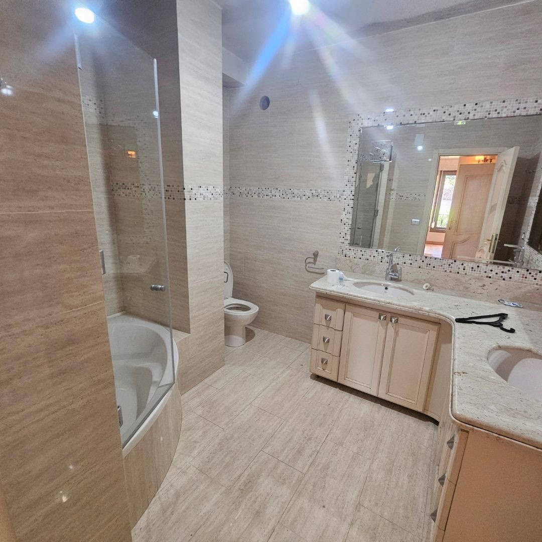 Modern bathroom with bathtub, toilet, and vanity in Maadi Cairo apartments for rent.