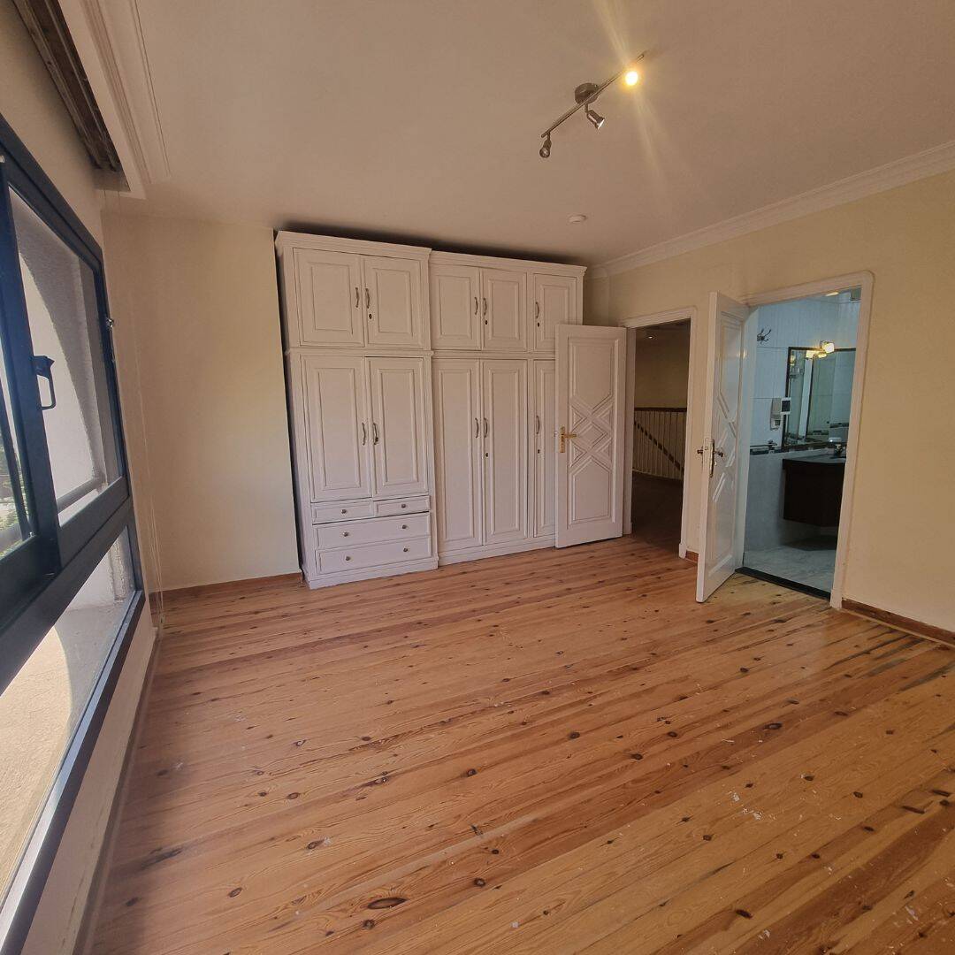 Spacious Duplex For Sale In Maadi Sarayat (5) Modern furnished bedroom with wooden flooring and built-in wardrobe in Maadi Cairo Egypt.