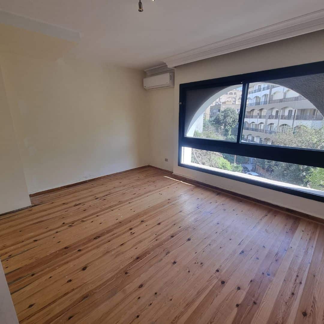 Spacious Duplex For Sale In Maadi Sarayat (8) Bright unfurnished apartment room with large window and wooden flooring in Maadi Cairo.